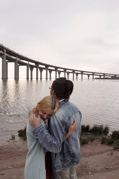 Free Man Hugging Woman Near Sea Stock Photo
