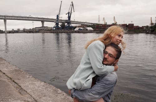 Un Uomo In Piedi Vicino Allo Specchio D'acqua Che Solleva Una Donna