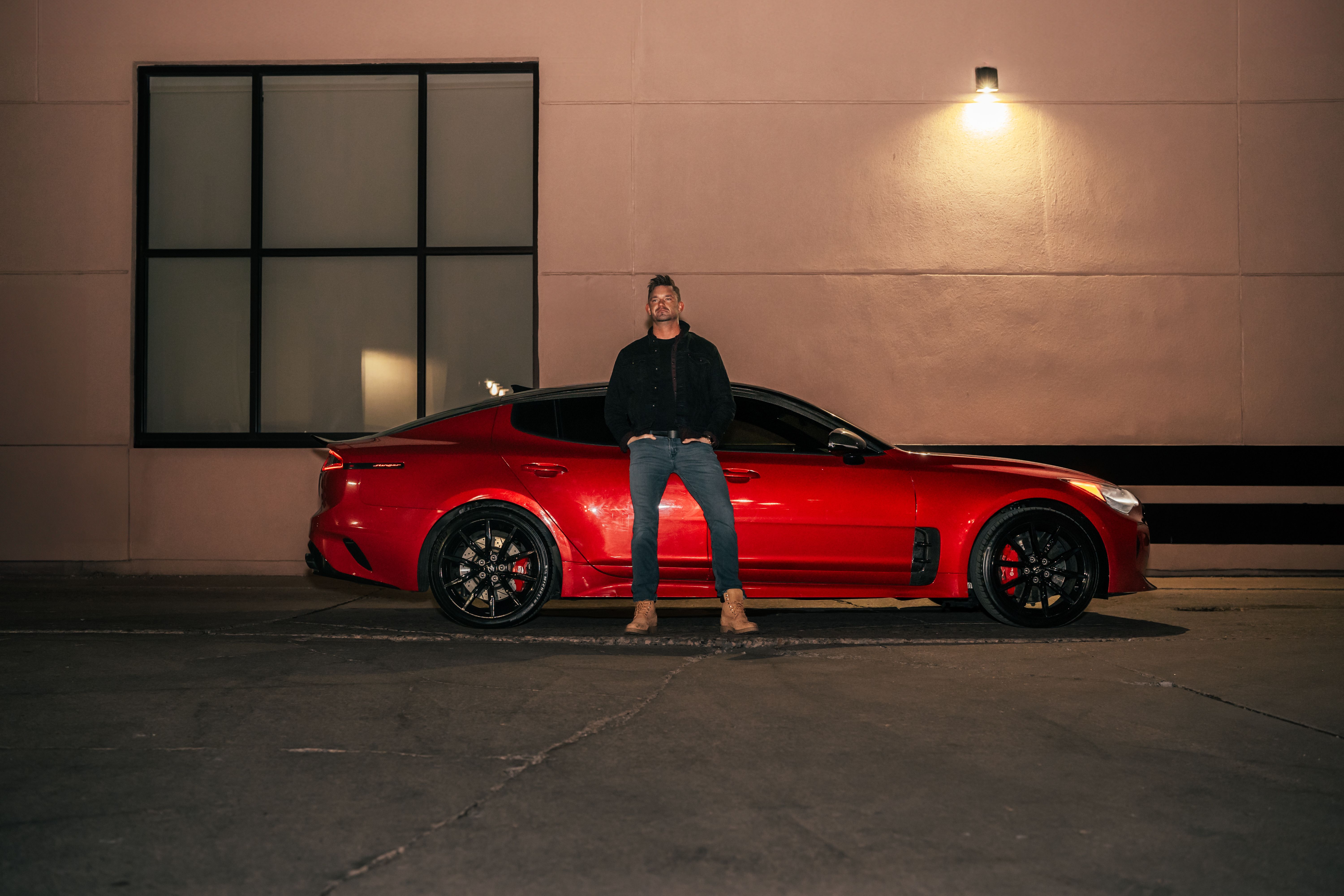 Man in Jeans Posing by Red Car · Free Stock Photo