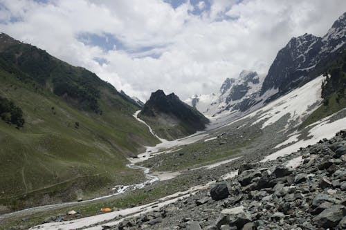 A view of a mountain valley with snow and rocks