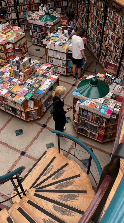 A woman is walking up a staircase in a bookstore