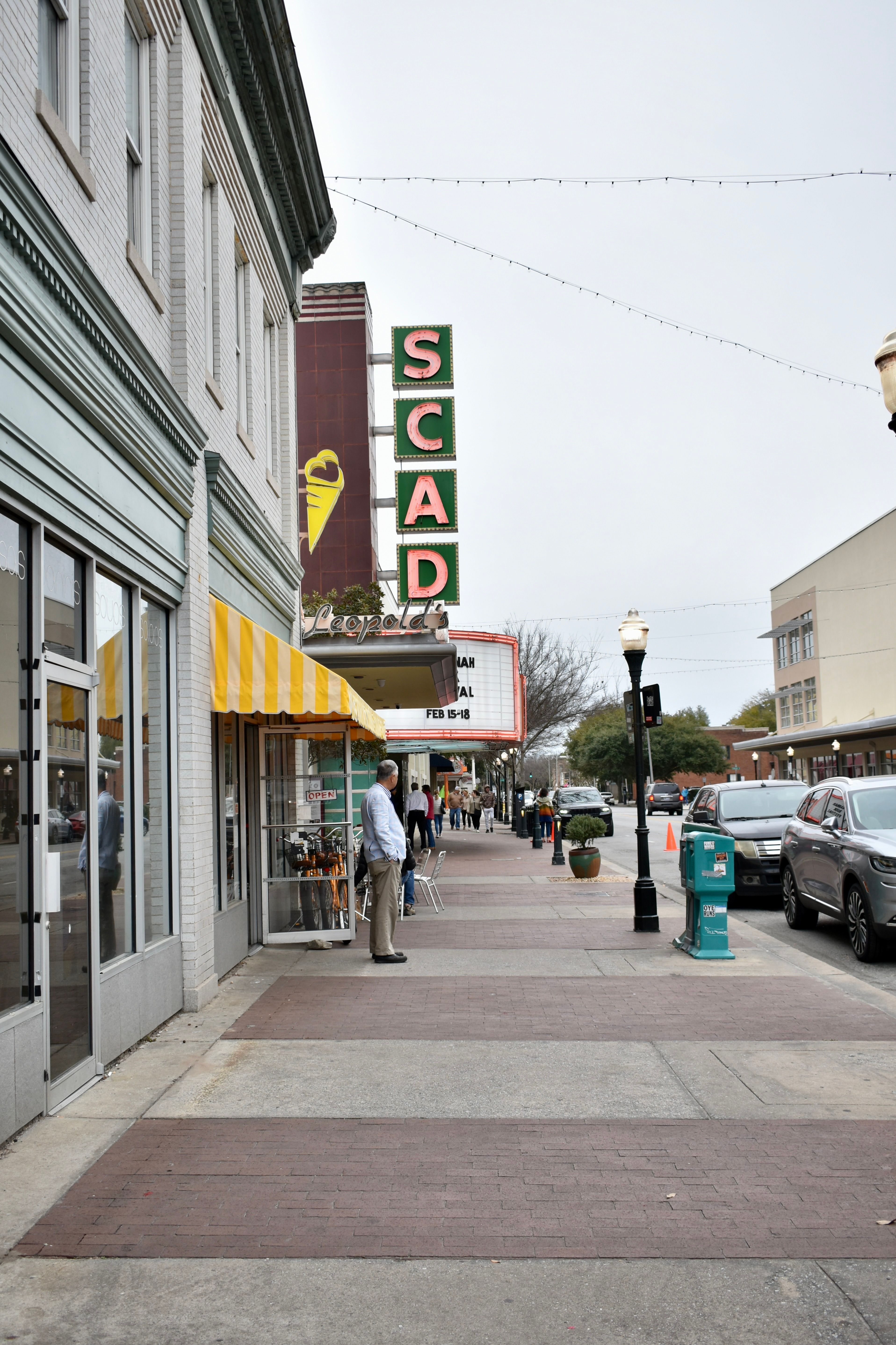 Vibrant city street in Savannah, GA featuring SCAD landmark and shops.