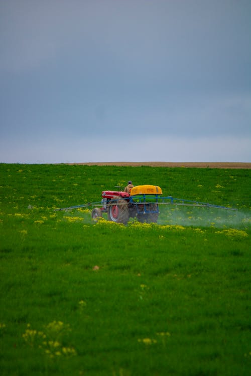 A tractor spraying a field of green grass