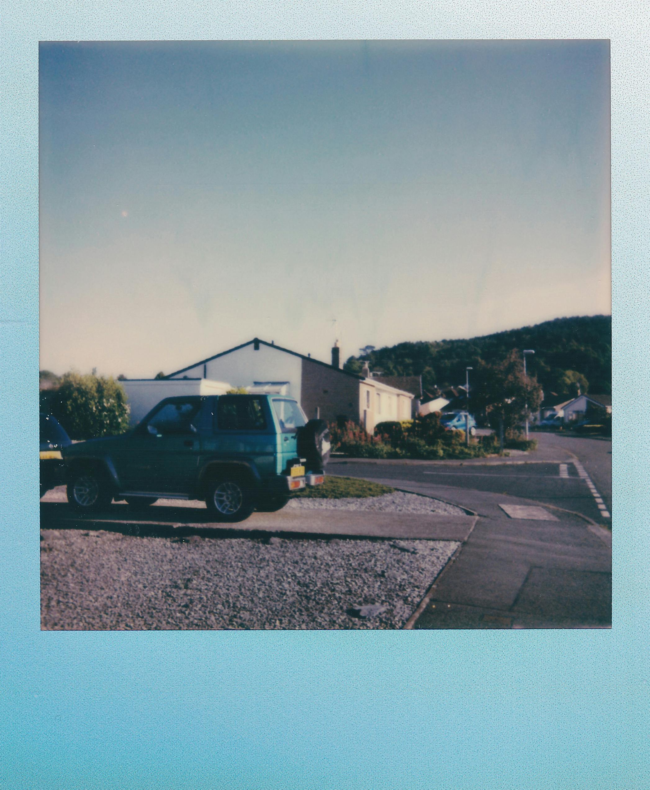 Classic SUV parked in a quiet suburban neighborhood at sunset, with a nostalgic retro vibe.