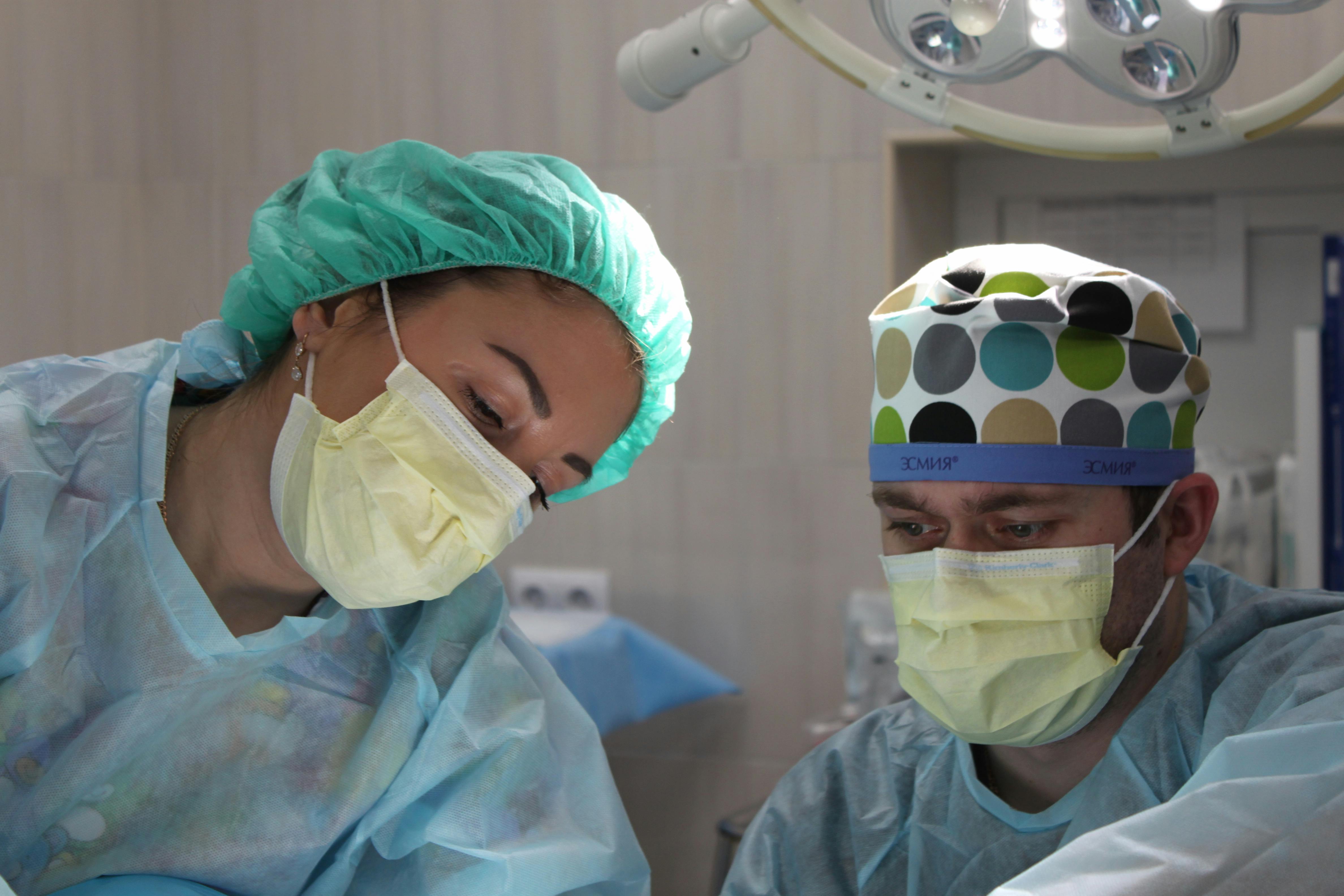 Two healthcare professionals in surgical masks and scrubs working together in a hospital, representing Kuwait’s growing demand for doctors, nurses, and medical staff under Vision 2035.