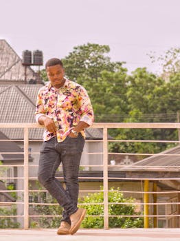 一位穿着充满活力衬衫的自信男人，在尼日利亚埃努古阳光明媚的户外摆着姿势