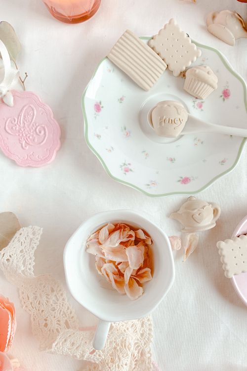 Free Top view of a beautifully arranged tea set with cookies and rose petals, perfect for an elegant tea time. Stock Photo