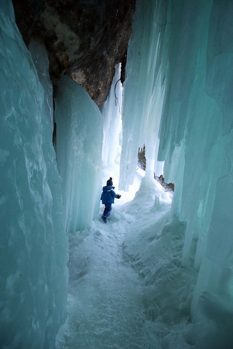 Kid Playing In A Cave With Snow