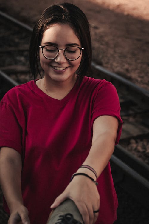 Gratis Wanita Yang Mengenakan Kacamata Dan Kaos Merah Muda Foto Stok