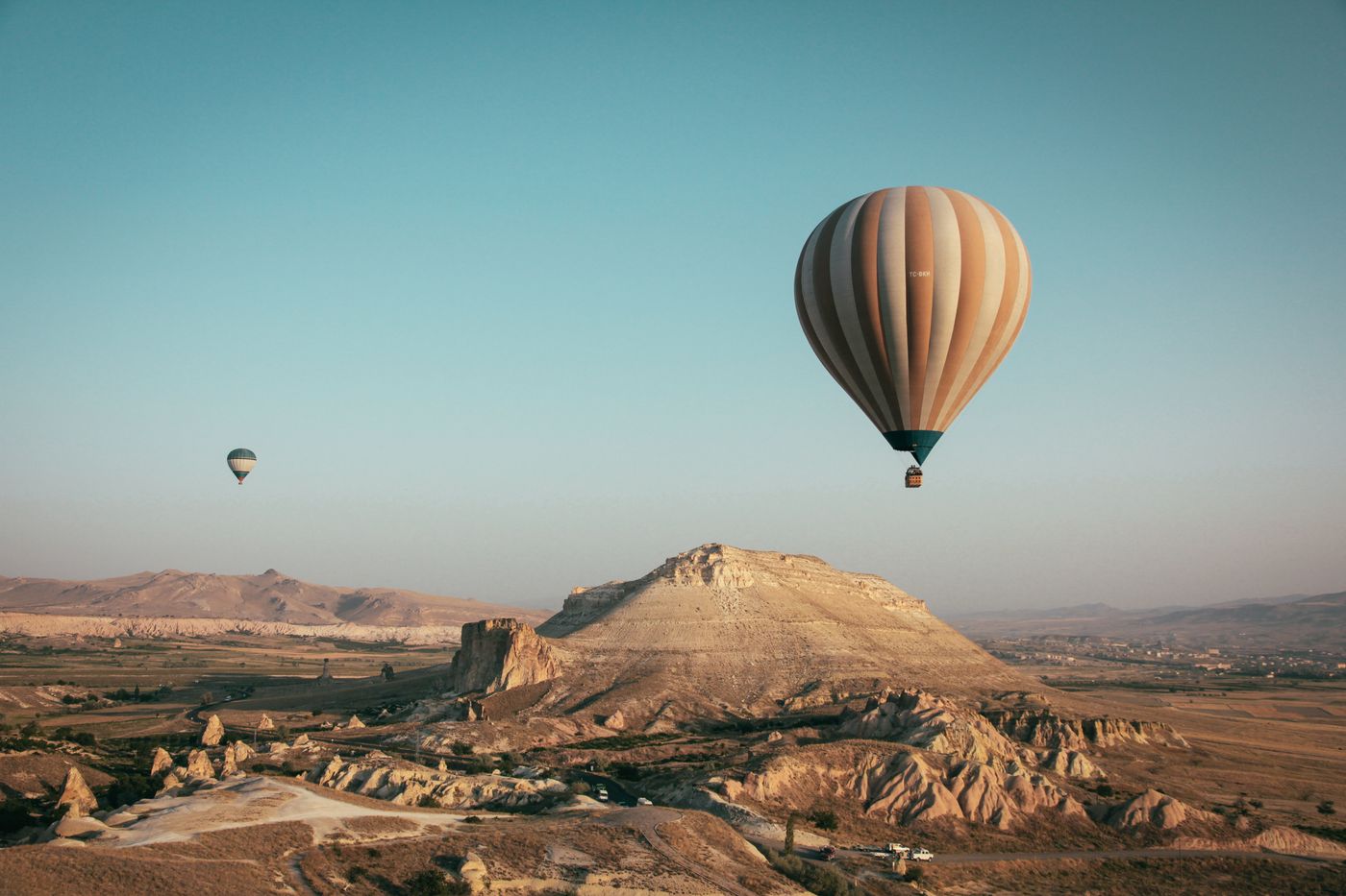 hot air balloons floating over dramatic landscape aerial view — drone photographer Amsterdam | ProShoot.io