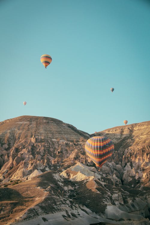 Free Hot Air Balloons Floating Above Mountains Stock Photo