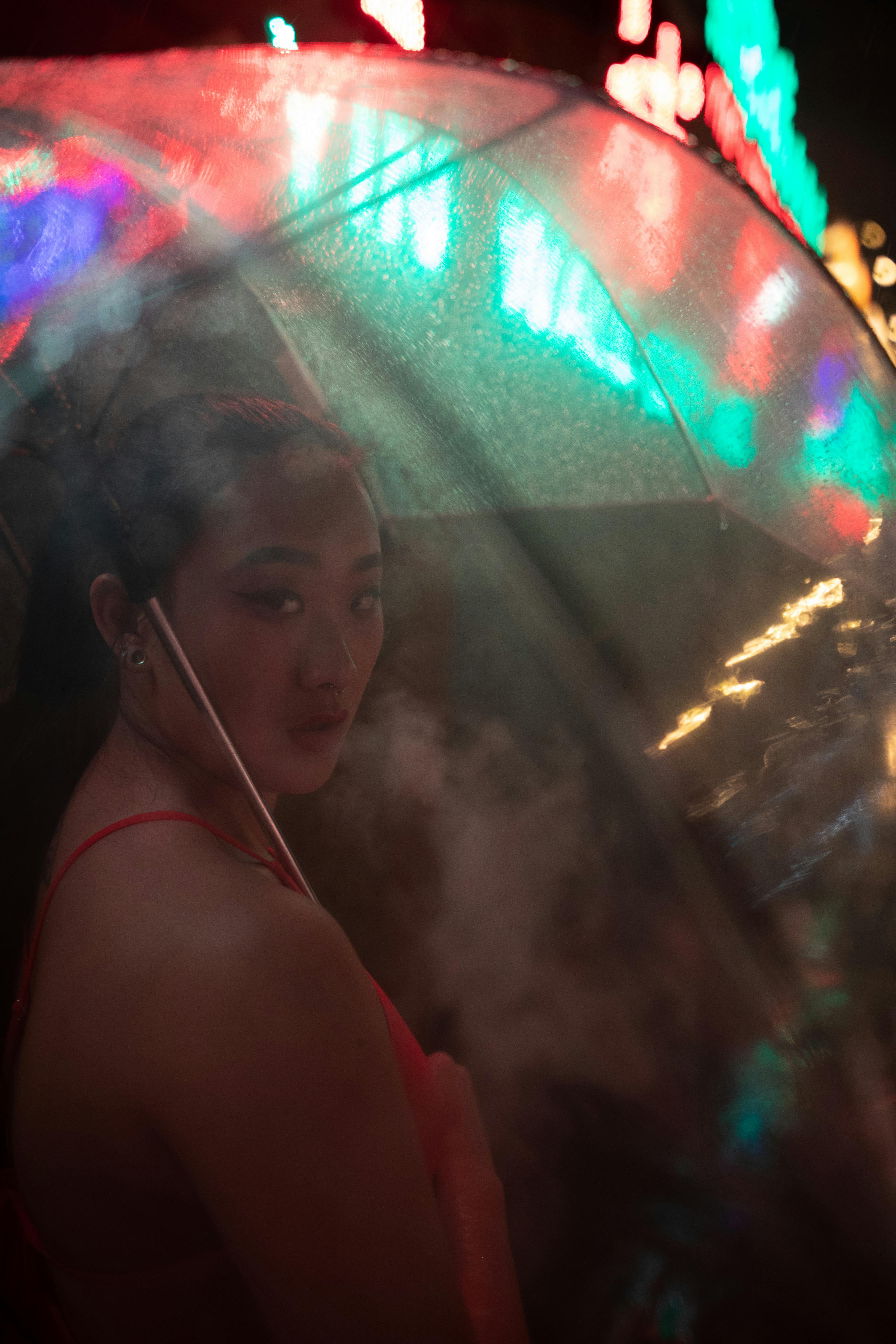 芝加哥雨夜中，一个女人撑着伞，走在灯火璀璨的街头