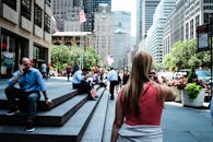 在繁华的纽约市街道上，人们在日光下与标志性的摩天大楼互动