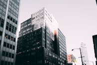 在城市景观中，白天可以看到带有玻璃幕墙的现代摩天大楼