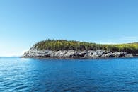 在蔚蓝海水的环绕中，探索一座晴朗天空下的宁静森林岛屿