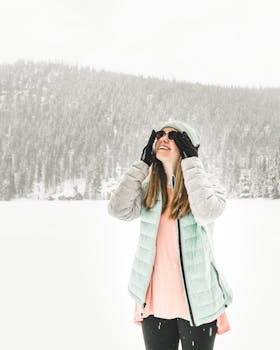 在科罗拉多埃斯蒂斯公园的森林里，一位穿着冬装的快乐女人正享受着下雪天