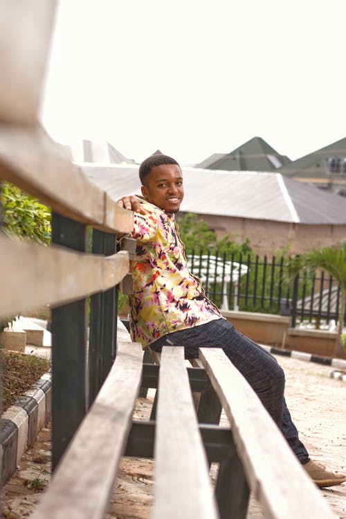 Photo of Smiling Man Sitting on Wooden Bench 