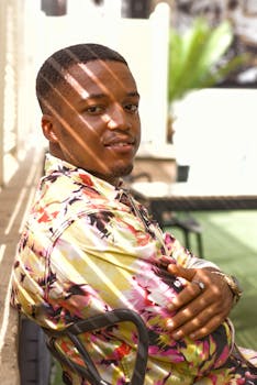 一名非洲男子坐在尼日利亚埃努古的户外，自然地微笑着