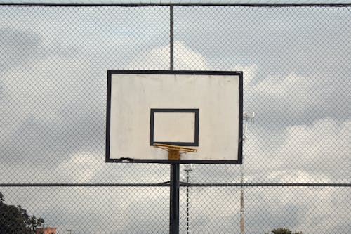 サイクロンフェンス近くのバスケットボールフープの写真
