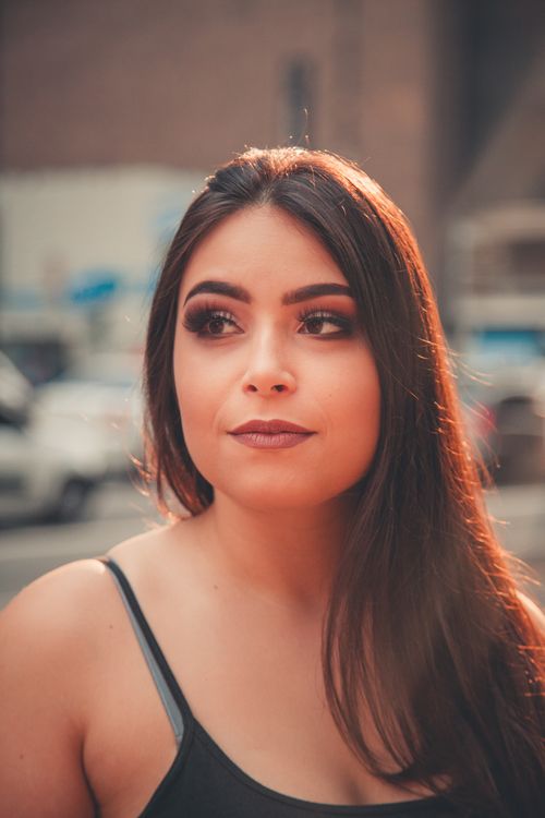 Free Captivating portrait of a woman in a city, exuding elegance and confidence with a soft expression. Stock Photo