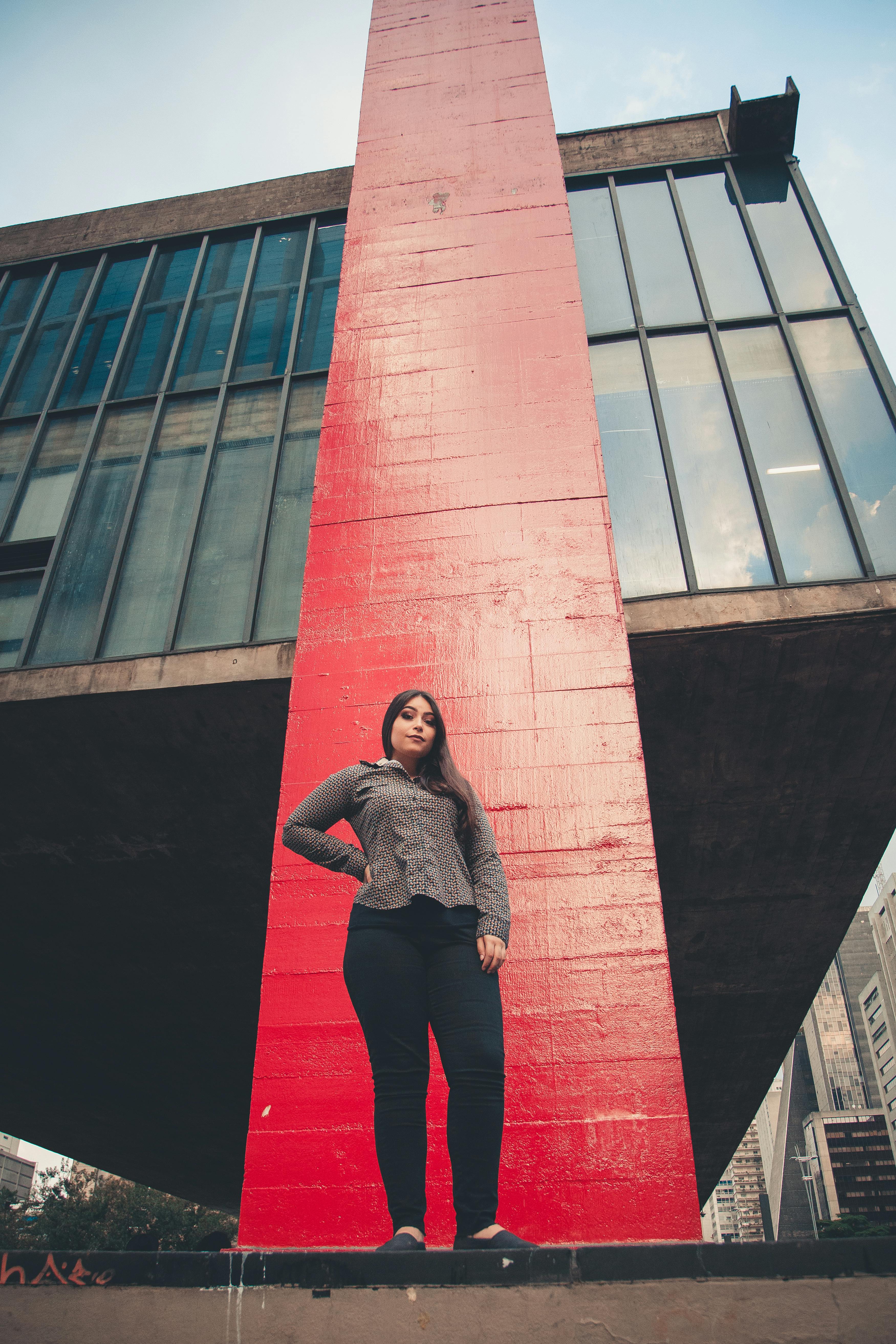 自信的女性在当代摩天大楼前摆出姿势，象征着赋权