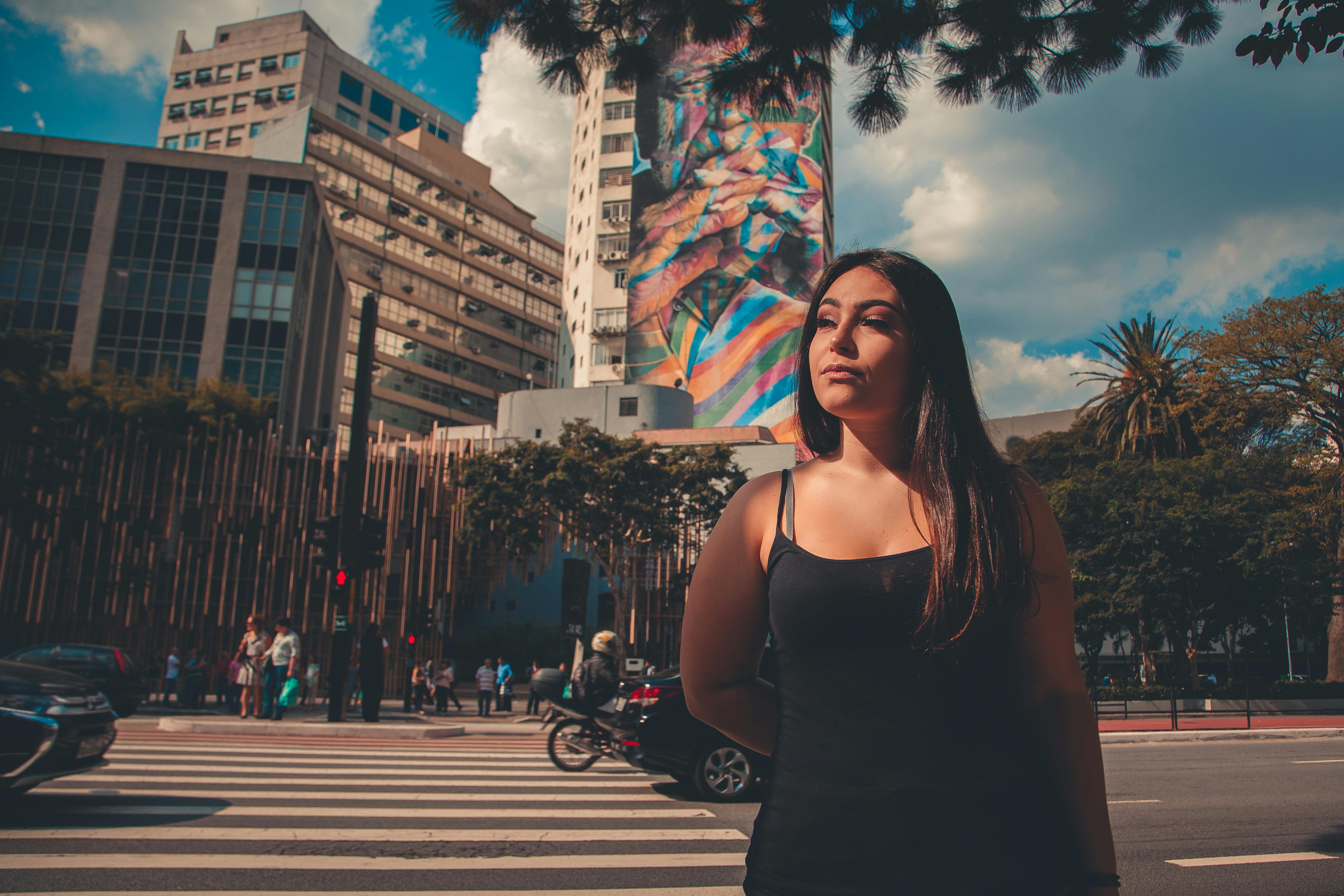 城市街道上，一个女人站在彩色壁画和建筑物前