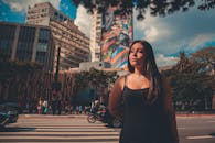 城市街道上，一个女人站在彩色壁画和建筑物前