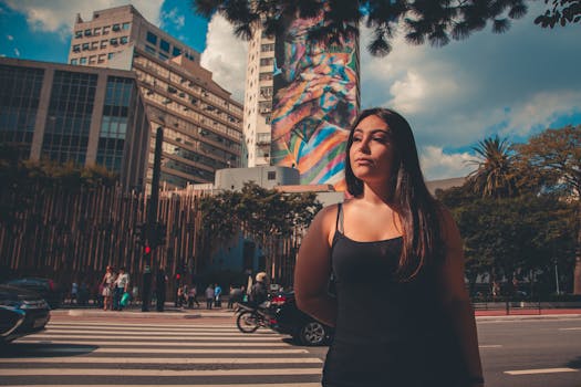 城市街道上，一个女人站在彩色壁画和建筑物前