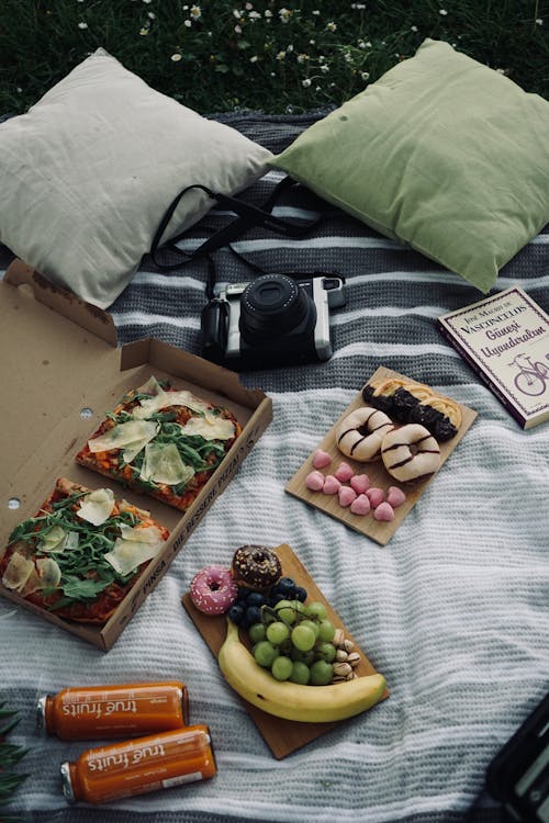 A picnic blanket with food and drinks on it