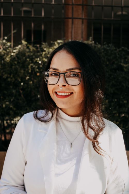 Free Stylish woman in a white jacket smiling outdoors, exuding confidence and elegance. Stock Photo