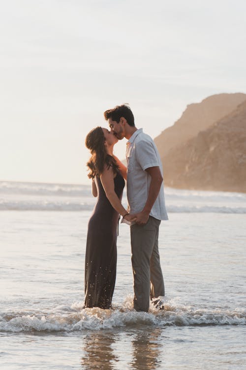A couple kissing in the ocean during their engagement session