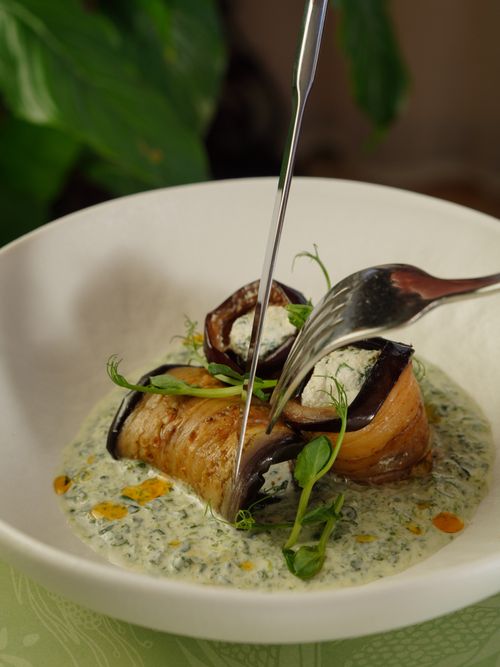 Free Mouthwatering eggplant roll elegantly served in a rich, creamy herb sauce with peas. Stock Photo