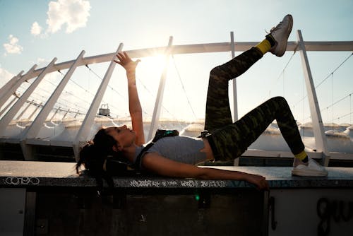 Woman Wearing Gray Top Lying on Concrete Platform