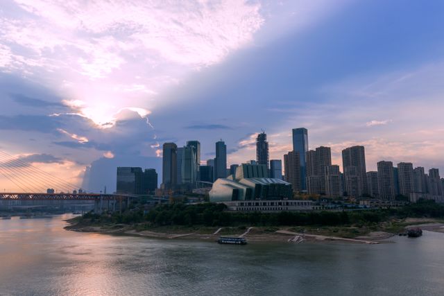 Panoramic view of the Chongqing skyline at dusk with a modern bridge over the Yangtze River.