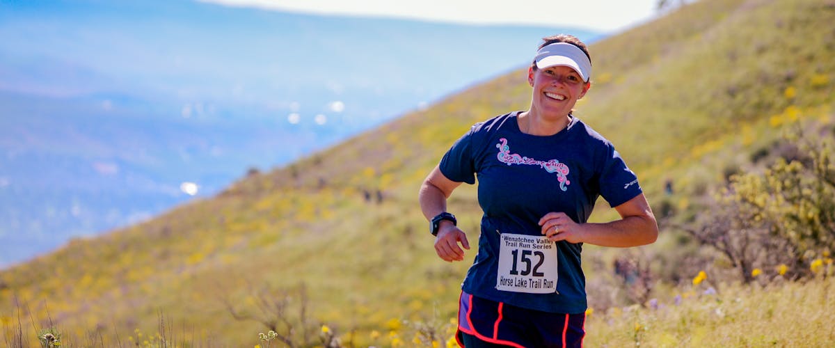 Corredor de trail running con mochila en montaña