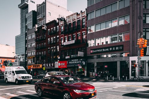 Free Vibrant street view of Chinatown in NYC with cars and diverse architecture under a bright sky. Stock Photo