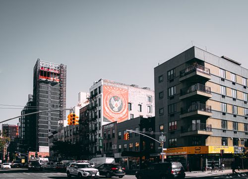 Free Cityscape of a busy urban intersection with modern buildings and street traffic during the day. Stock Photo
