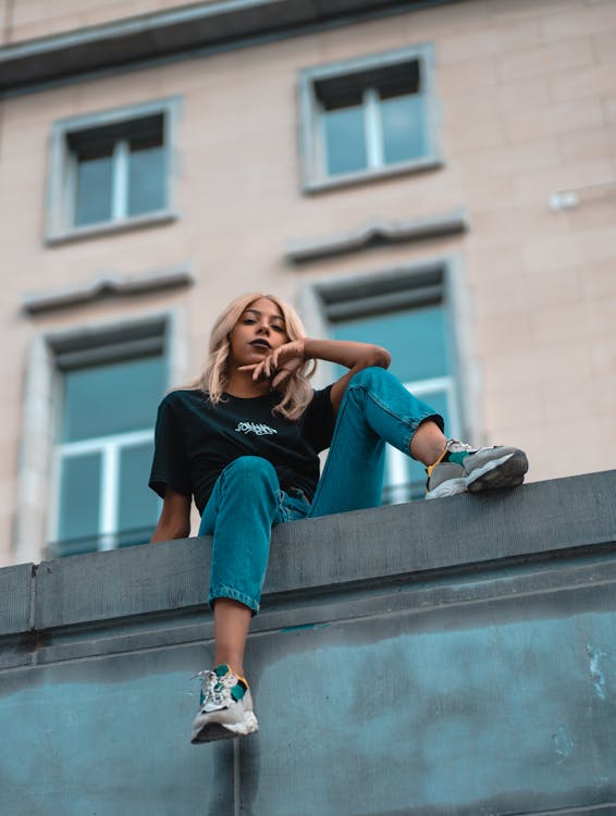 Vrouw Met Blond Haar Zit Bovenop Het Gebouw