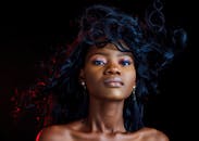 一幅自信女性的肖像引人注目，戏剧性的照明与发型更添风采