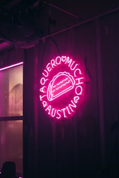 Bright pink neon sign of a taco displayed at Taquero Mucho, Austin, Texas.
