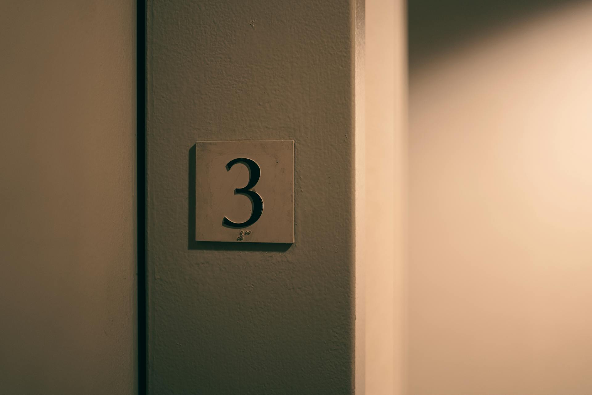 Plate with the Number 3 and a Braille Marking on the Wall Beam