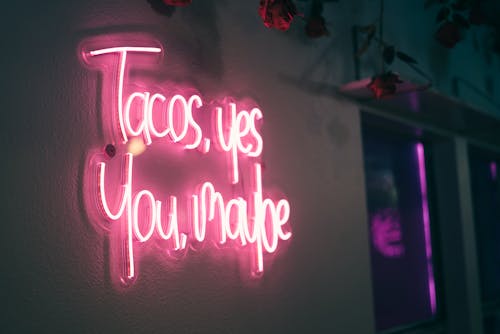 A neon sign that says tacos, you make me
