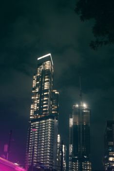 Nighttime cityscape featuring illuminated skyscrapers in an urban setting, perfect for travel or architecture themes.