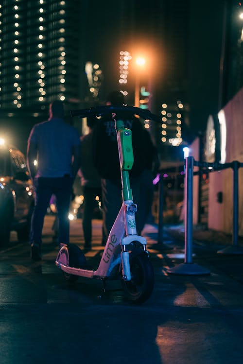 A person riding a scooter at night on a street
