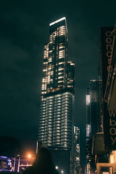 Stunning view of a skyscraper lit up against the night sky in Bogotá, showcasing modern urban architecture.