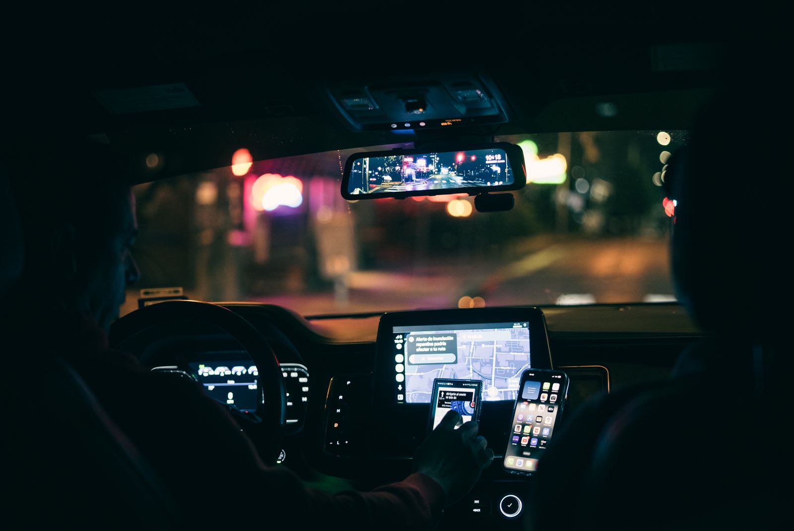 Rideshare driver using navigation inside a car at night