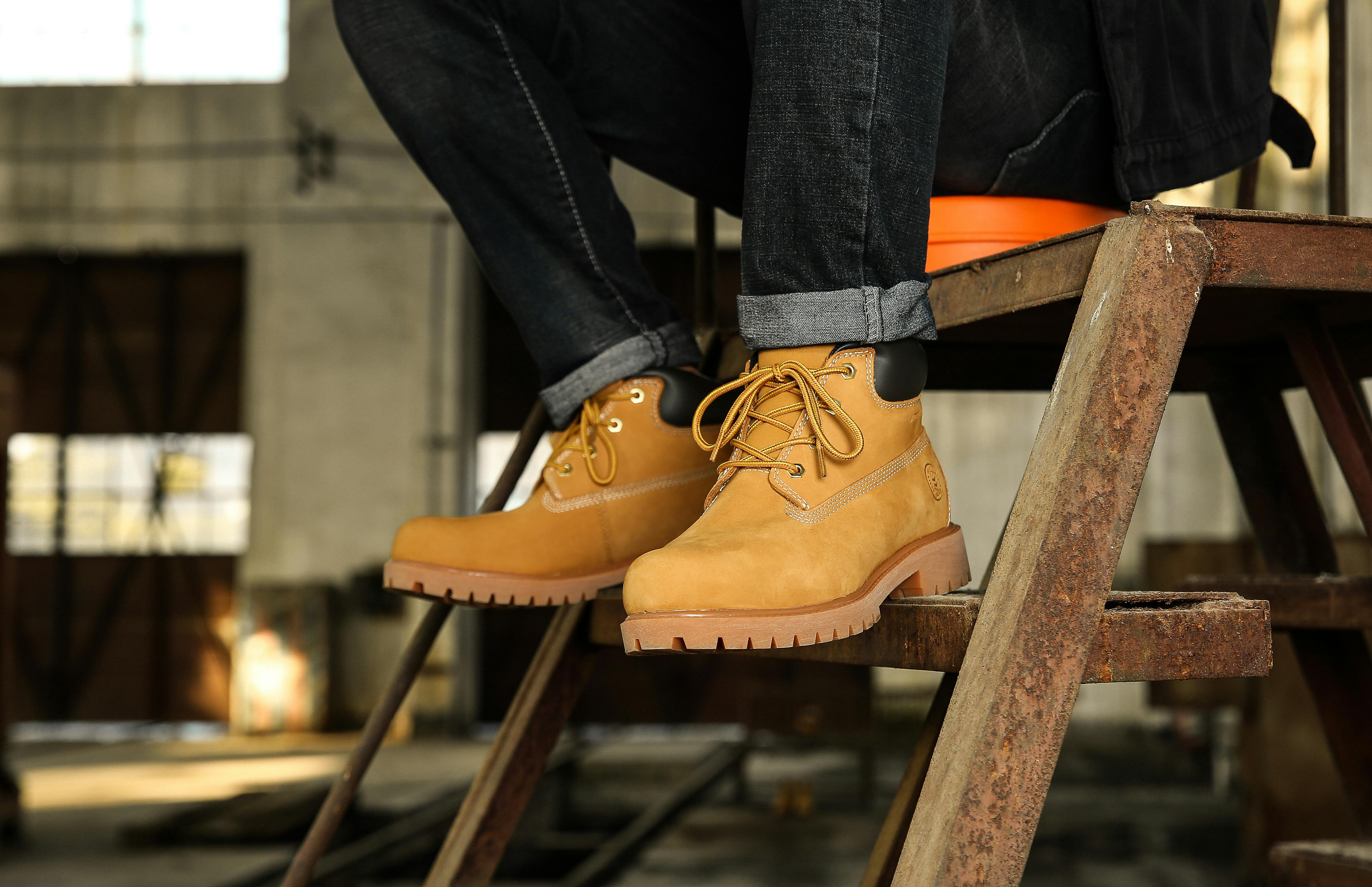 legs of a man wearing brown hiking boots