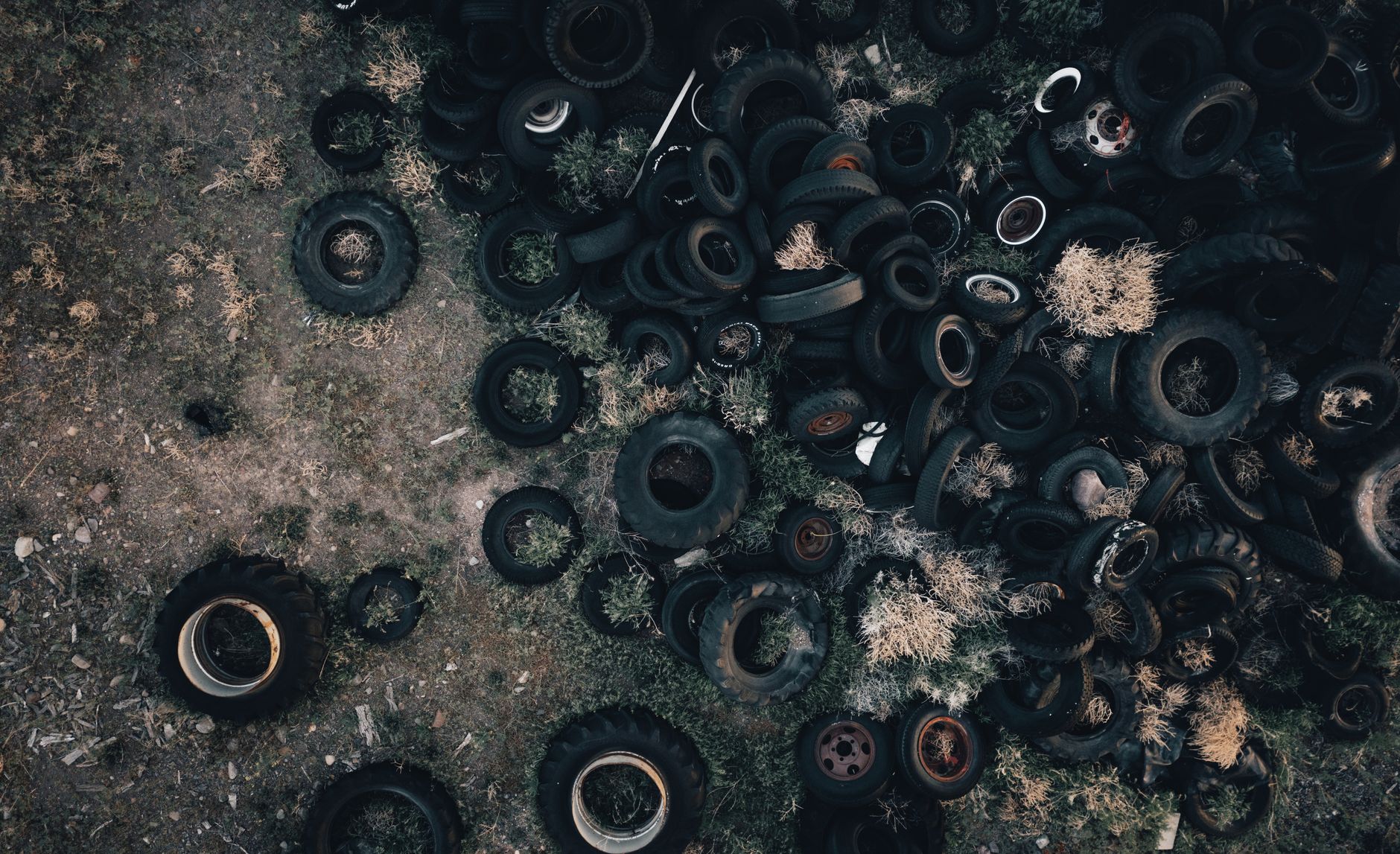 Explore a captivating aerial view of discarded tires scattered across a grassy field in Monroe, Utah.