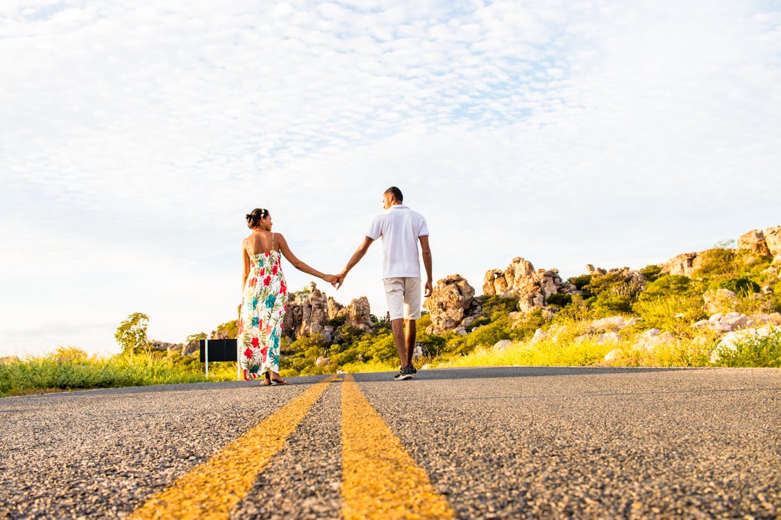 Free Couple holding hands on mountain road Stock Photo