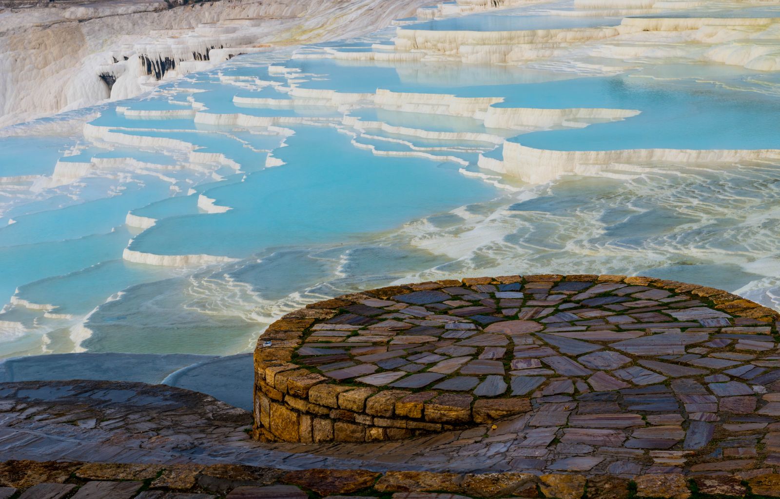Walk barefoot across the white travertine terraces of Pamukkale